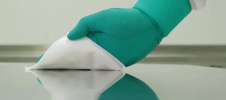 compounding-pharmacist with a gloved hand using a hydroflex cleanroom wipe