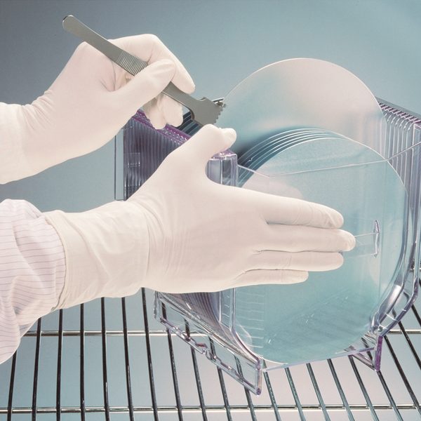 cleanroom worker holding a rack of stainless steel dishes while wearing sterile kimtech g3 nitrile gloves