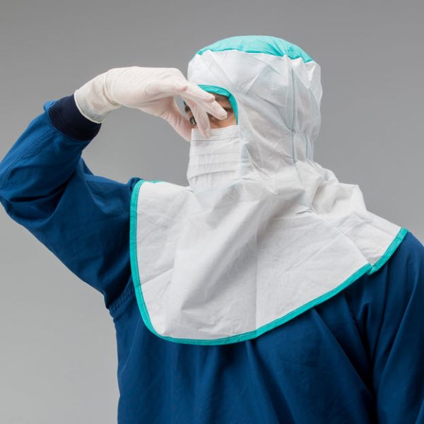 cleanroom worker adjusting the nose bridge of a vai veltek 1700 mp hood with full-face coverage