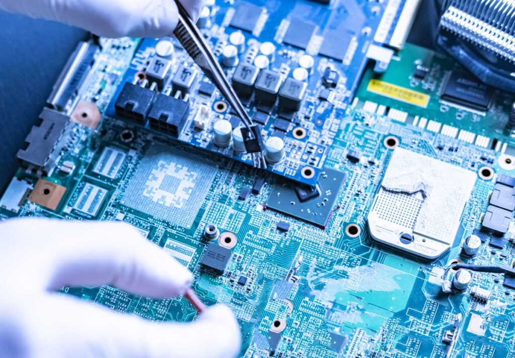 cleanroom technician wearing anti-static gloves mounting chip onto motherboard