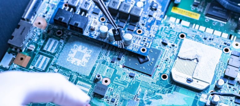 cleanroom technician wearing anti-static gloves mounting chip onto motherboard