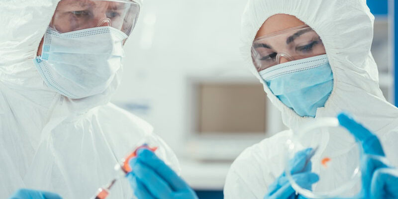 pharmaceutical manufacturing cleanroom technicians preparing a petri dish for a culture