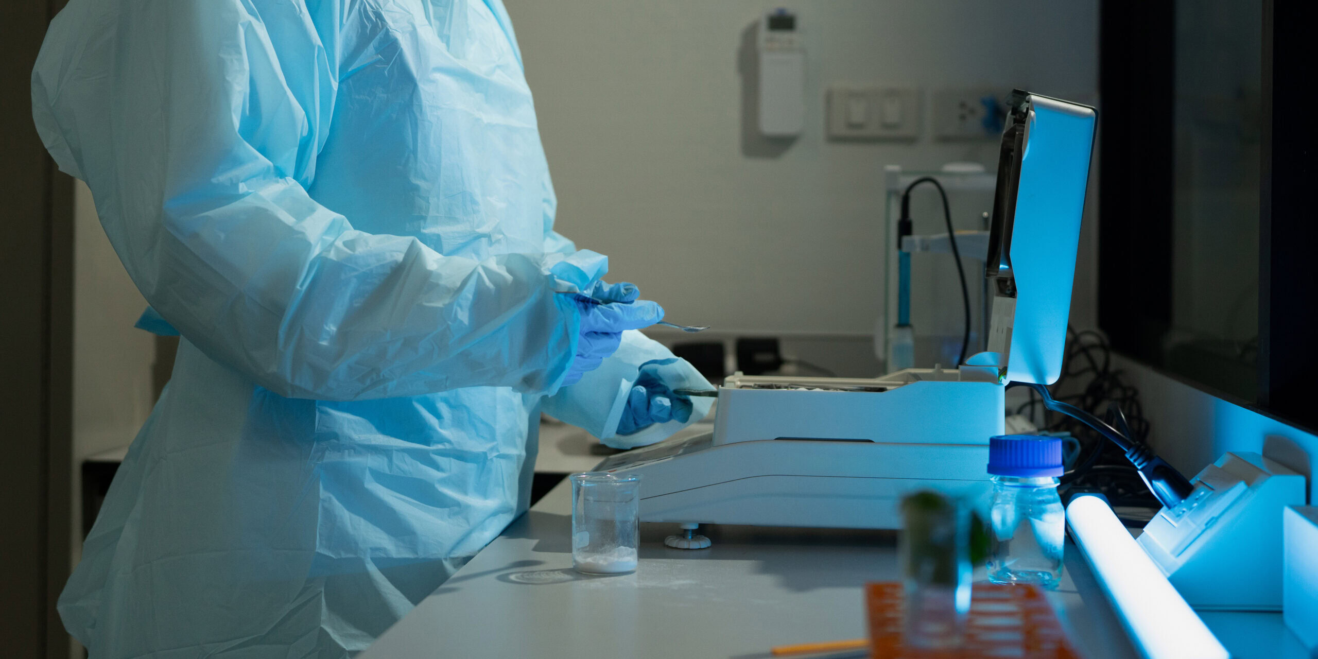 scientist in protective suit working with laboratory equipment and samples in research facility