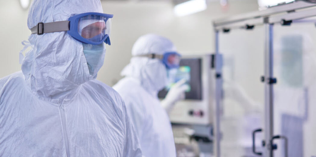 workers wearing sterile tyvek isoclean coveralls in a environment